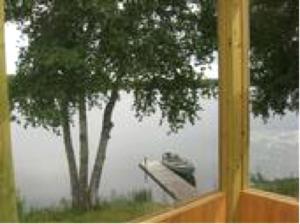 a window with a tree and a boat in the water at Lakeside Cabin Rental with a Boat Dock in Pine River, Minnesota in Pine River