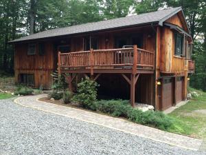 una grande cabina di legno con un ponte su una casa di Mountain Cabin Rental with Modern Amenities in Lake Placid, New York a Whiteface