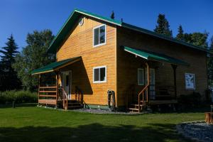 une maison en bois avec une véranda et une véranda dans l'établissement Spacious Family Cabin with Scenic Views near the Kenai River in Alaska, à Kasilof 17 autres photos