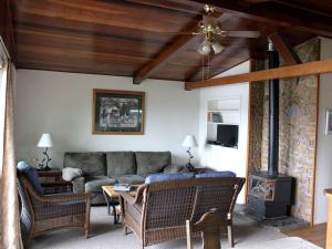 a living room with a couch and a fireplace at Inviting Cabin Getaway on a Private Lake on the Kenai Peninsula, Alaska in Kasilof