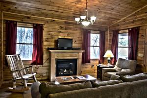 a living room with a couch and a fireplace at Romantic Forest Cabin Getaway near Cantwell Cliffs in Logan, Ohio in Cedar Grove