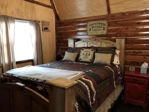 a bedroom with a bed in a log cabin at Cozy Cabin Rental on Vineyard in Allen, Oklahoma in Allen
