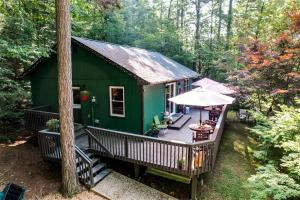 a green cabin with a deck in the woods at Remote Vintage Camper Rental for Adult-Only Retreat in Franklin, North Carolina in Franklin +23 photos