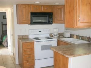 eine Küche mit einem weißen Herd und einer Mikrowelle in der Unterkunft Cozy Cottage Rental for Eight with Lake Views in New Braunfels, Texas in Schumannsville