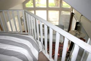 ein Schlafzimmer mit einem Bett und eine Treppe mit einem Fenster in der Unterkunft Cozy Cottage Rental for Eight with Lake Views in New Braunfels, Texas in Schumannsville + 6 Fotos