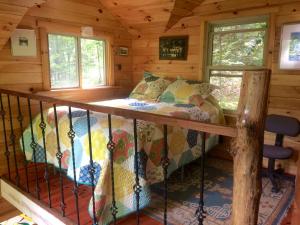 1 dormitorio en una cabaña de madera con 1 cama en Rustic Off-Grid Cabin Getaway near Wayne National Forest, Ohio, en Athens