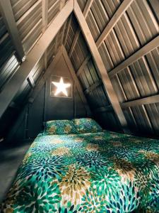 une chambre avec un lit avec une étoile dessus dans l'établissement Secluded A-Frame Glamping on 46-Acre Farm Near Nashville – Queen Beds, Fire Pit, Breakfast Included, à Lebanon