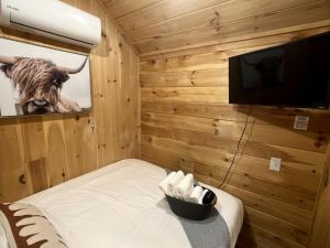 a room with a television and a cow on the wall at Quaint Tiny House Haven in Colorado: Your Dream Glamping Getaway in Grand Junction in Grand Junction