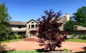 une maison avec un arbre dans la cour avant dans l'établissement Spacious Cottage with Pool for an Exciting Getaway on Smith Lake in Alabama, à Brushy Pond