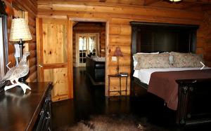 une chambre avec un lit dans une cabane en bois dans l'établissement Luxury Cabin with a Hot Tub near Yellowstone Park in Montana, à Nye