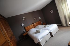 two beds in a bedroom with black walls at Logis Hotel Restaurant Au Boeuf Rouge in Niederschaeffolsheim