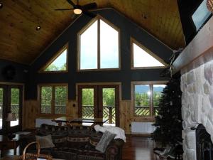 a living room with a couch and a fireplace at Impressive Cabin Rental for Large Groups in Au Sable Forks, New York in Black Brook