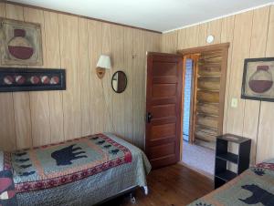 Un dormitorio con dos camas y una puerta a una habitación. en Rustic Two-Story Cabin Rental with Lake Access in Hayward, Wisconsin, en New Post 6 fotos más