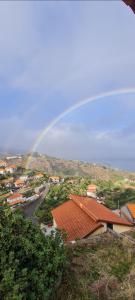 a rainbow in the sky over a town with a street at Refúgio das Regadinhas in Santa Cruz