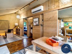 a room with wood paneling and a room with a table at Incredible Tented Cabin with Fire Pit and Hot-tub in Sevierville, Tennessee in Wear Valley
