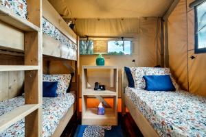 two beds in a tiny house with a window at Incredible Tented Cabin with Fire Pit and Hot-tub in Sevierville, Tennessee in Wear Valley