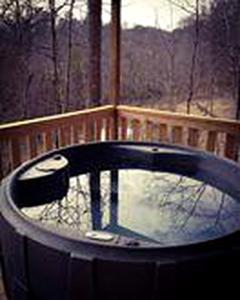 a jacuzzi tub on a deck with a fence at Luxury Cabin Rental with Beautiful Water Views near Charlotte, North Carolina in Elkin