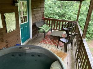 a hot tub on a deck with a table and chairs at Luxury Cabin Rental with Beautiful Water Views near Charlotte, North Carolina in Elkin