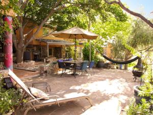 a patio with a table and chairs and an umbrella at Rural Getaway Adjacent to the Prescott National Forest in Clarkdale, Arizona in Jerome