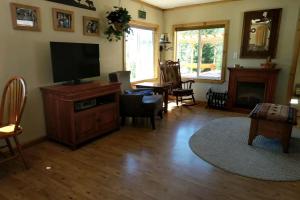 a living room with a flat screen tv and a fireplace at Rustic Mountain Retreat Perfect for Large Groups in Kingston, Idaho in Smelterville +32 photos
