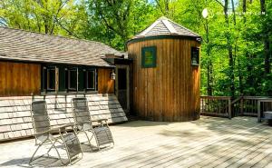 a wooden cabin with two chairs on a deck at Peaceful Getaway above a Beautiful Yoga Studio near Devil's Den Nature Preserve, Connecticut in Redding