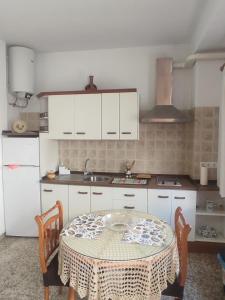 a kitchen with a table and a sink and white cabinets at Casa Arriate in Cómpeta +7 photos