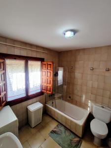 a bathroom with a tub and a toilet and a sink at Casa Arriate in Cómpeta