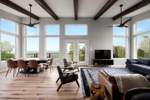 a living room with a table and chairs and windows at Scenic Getaway Cabin w/ Fire Pit, Deck & Panoramic Views in Martinsburg, WV in Martinsburg