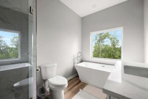 a bathroom with a tub and a toilet and a window at Scenic Getaway Cabin w/ Fire Pit, Deck & Panoramic Views in Martinsburg, WV in Martinsburg +15 photos