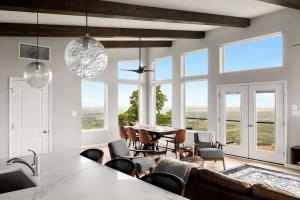 a dining room with a table and chairs and windows at Scenic Getaway Cabin w/ Fire Pit, Deck & Panoramic Views in Martinsburg, WV in Martinsburg