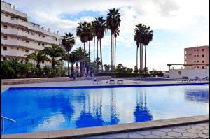 una gran piscina con palmeras en el fondo en Vina del Mar Playa de LasAmericas, floor8 sea view, en Playa de las Américas