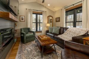 a living room with a leather couch and a fireplace at Chic Modern Cabin with Jacuzzi Ideal for Couples in Carbondale, Illinois in Makanda