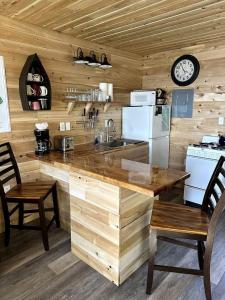a kitchen with a counter with a sink and a clock at Magnificent Cabin Nestled Amidst Trees in Portage Lake, Maine in Portage Lake Municipal Seaplane Base +8 photos