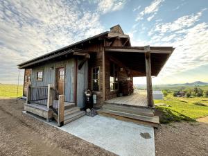 a small wooden house with a porch and a balcony at Charming Historic-Inspired Vacation Home with Mountain Views near Pony School House in Pony, Montana in Pony