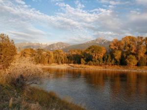 a river with trees and mountains in the background at Remote Six-Bedroom Lodge for Rent near the Chico Hot Springs, Montana in Flying Y Ranch Airport
