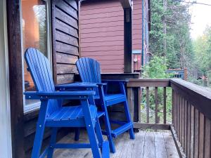 zwei blaue Stühle auf der Veranda einer Hütte in der Unterkunft Enchanting Creekside Cabin Retreat near Yosemite National Park in California in Fish Camp