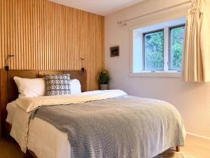 ein Schlafzimmer mit großem Bett und Fenster in der Unterkunft Enchanting Creekside Cabin Retreat near Yosemite National Park in California in Fish Camp