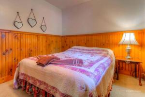 1 dormitorio con 1 cama con paneles de madera en las paredes en Traditional Wooden Cabin Rental in the Poconos, Pennsylvania, en Canadensis