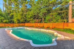 Una piscina en un patio trasero con una valla naranja. en Traditional Wooden Cabin Rental in the Poconos, Pennsylvania, en Canadensis