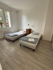 a room with two beds and a window at Hebergements le Camp d'Auneau - Leboudubout in Auneau