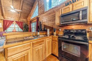 - une cuisine avec des armoires et des appareils en bois dans une cabine dans l'établissement Cozy Secluded Cabin with Fire Pit and Barbecue and Access to Fantastic Hiking Trails in Cleveland, Georgia, à Kinseytown