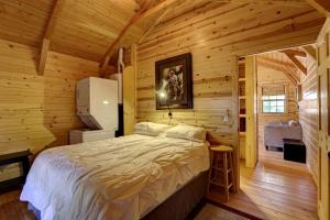 a bedroom with a bed in a wooden cabin at Cozy Cabin Perfect for a Romantic Escape with BBQ in Dayton, Wyoming in Ranchester