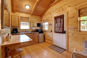 a kitchen with wooden walls and a door in a cabin at Cozy Cabin Perfect for a Romantic Escape with BBQ in Dayton, Wyoming in Ranchester +56 photos