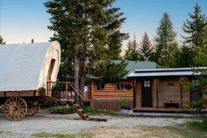 eine Hütte mit einer Pferdekutsche davor in der Unterkunft Unique Conestoga Glamping Wagon with King Bed & Private Bath | Bonners Ferry, Idaho Retreat in Bonners Ferry