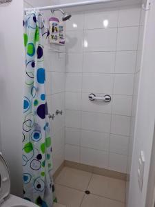 a bathroom with a shower curtain and a toilet at Hermoso departamento cerca a parque y estadio nacional con cochera in Lima