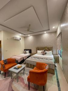 a bedroom with two beds and a table and chairs at Dream Lodge House in Islamabad
