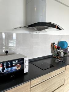 a kitchen with a stove and a microwave at EVO Soho Bangi Netflix putrajaya early check-in in Bandar Baru Bangi
