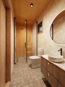 un bagno con un water, un lavandino e uno specchio di Tyven Resort a Sirkkakoski