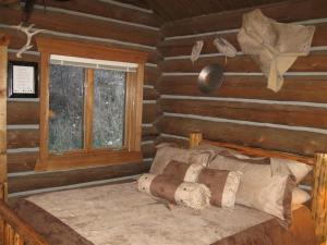 a bedroom with a bed in a log cabin at Rocky Mountains Nature Escape: Amazing Log Cabin with a Hot Tub in Darby, MT in Peaks and Pines Park