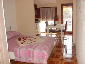 a room with a bed and a table and a kitchen at Apartments Špiko in Hvar